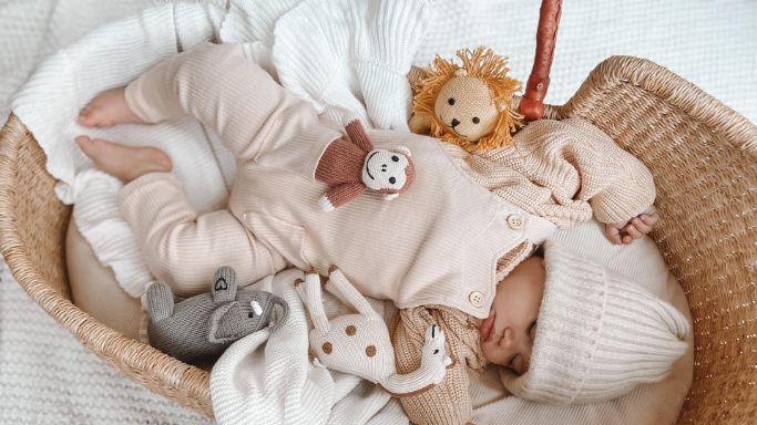 Baby napping with toy rattles