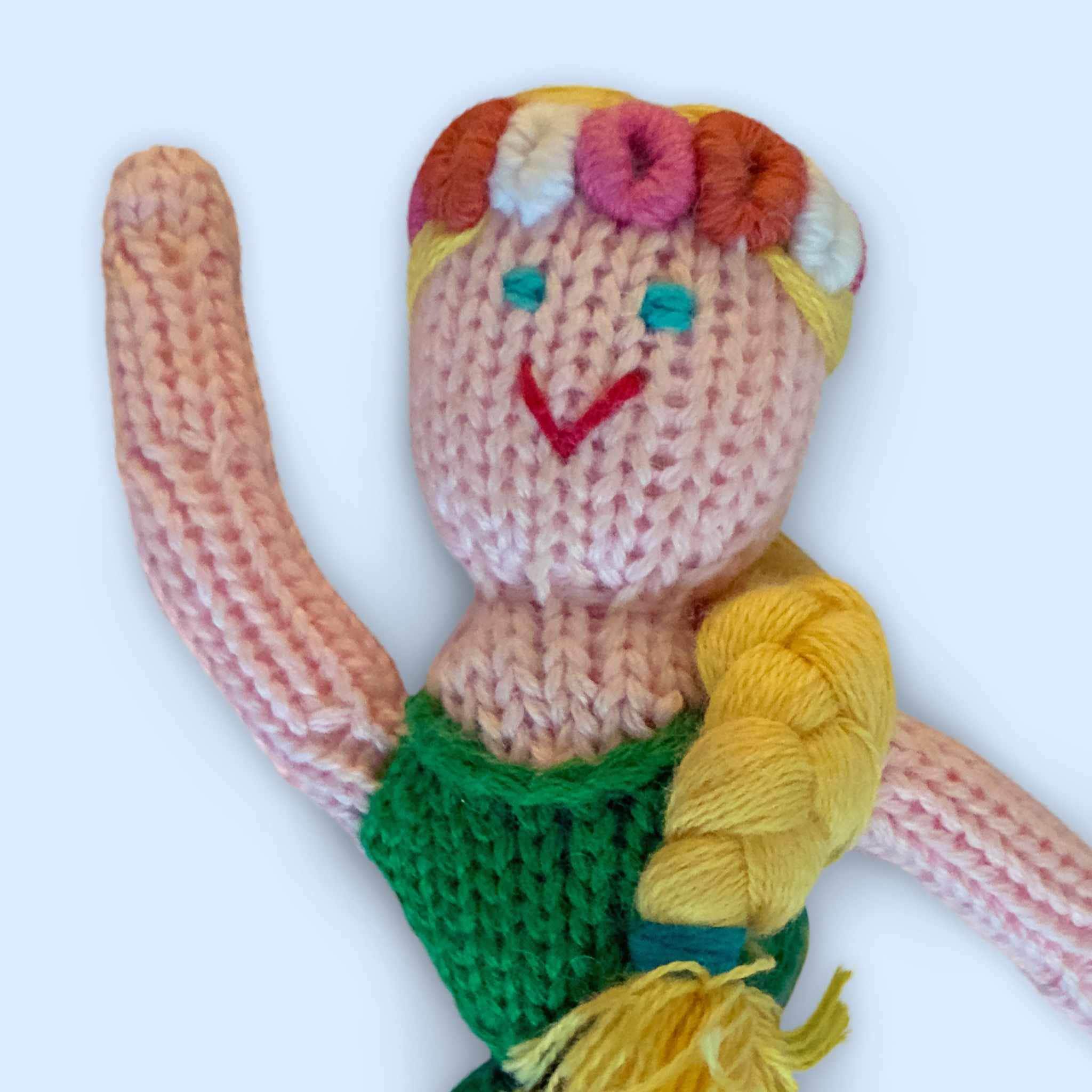 Estella Animal Rattle Toy For Babies, Showing Detailed Face Of Knit Mermaid Rattle In Organic Cotton On Blue Background.