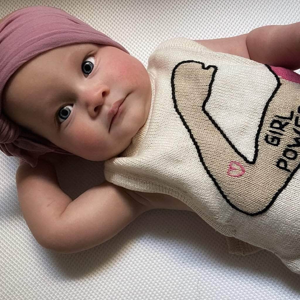 Photo of baby girl wearing the cream colored "girl power" summer romper