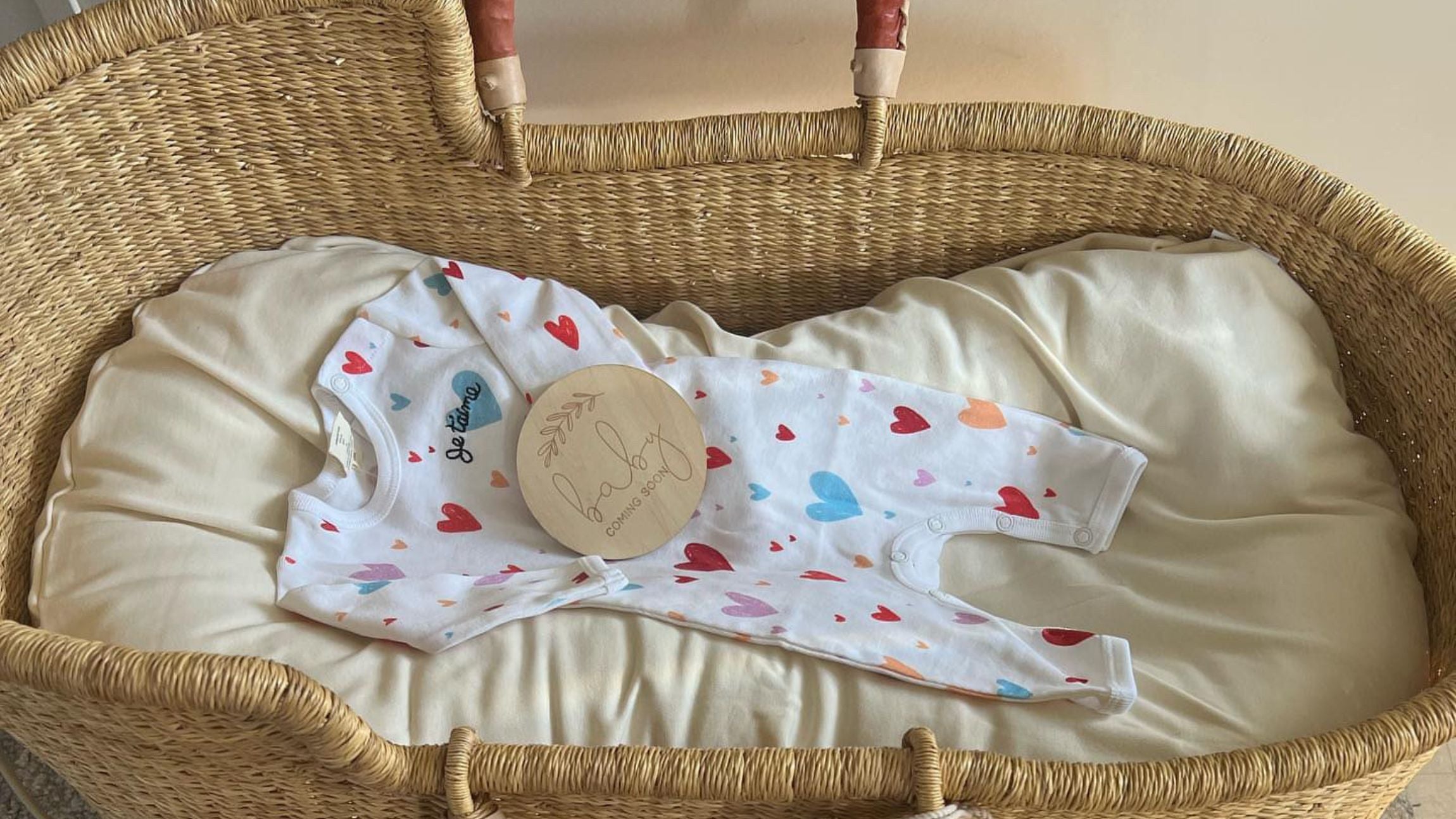 Organic baby romper displayed in a baby basket