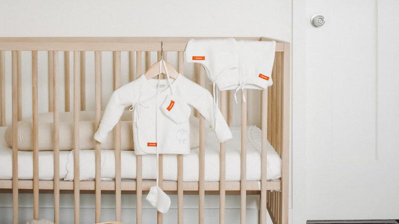 Baby crib with clothes hanging on it