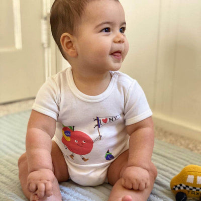 Baby wearing Estella organic onesie with 'I love NY' Print.
