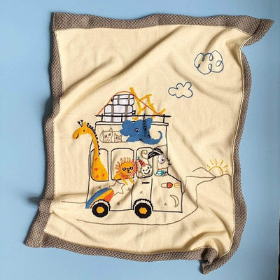 knit baby animal road trip blanket. grey border, cream background, yellow giraffe, blue elephant, lion, monkey, dog in a car. 