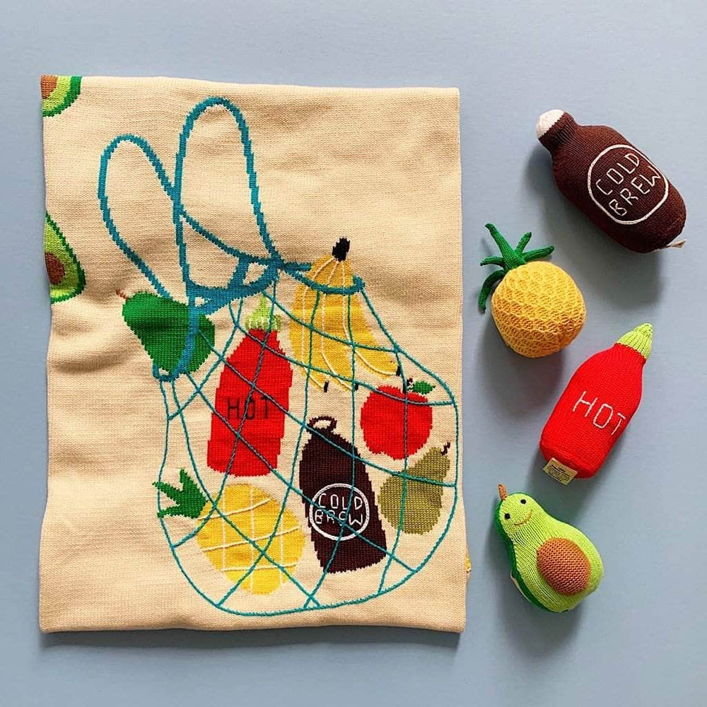organic baby gift set blanket, hot sauce, cold brew, pineapple, and avocado rattle.