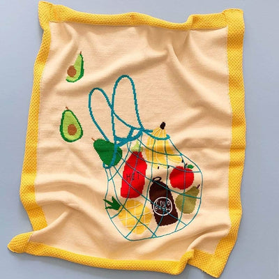 organic baby blanket with avocado, banana, pear, apple, pineapple, cold brew and hot sauce image in the front.