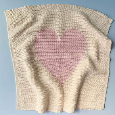 organic pink heart blanket. Pink heart and white cream background.