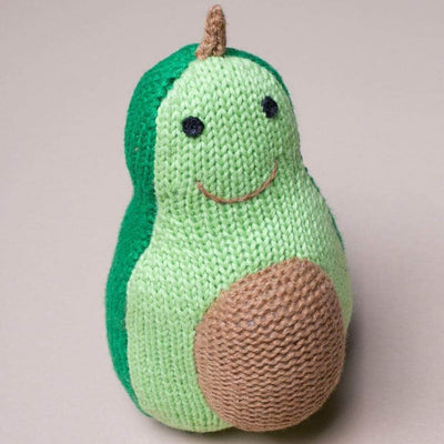 Soft baby toy rattle shaped like an avocado with a dark green back and a lighter green front, smiling face and brown round intarsia on the stomach resembling the pit.