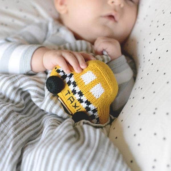 Organic Baby Toy | Infant holding his favorite organic cotton taxi rattle toy while sleeping.