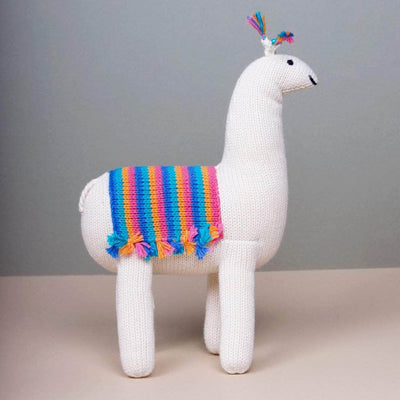 side photo of stuff toy alpaca. Cream, blue, orange, pink.