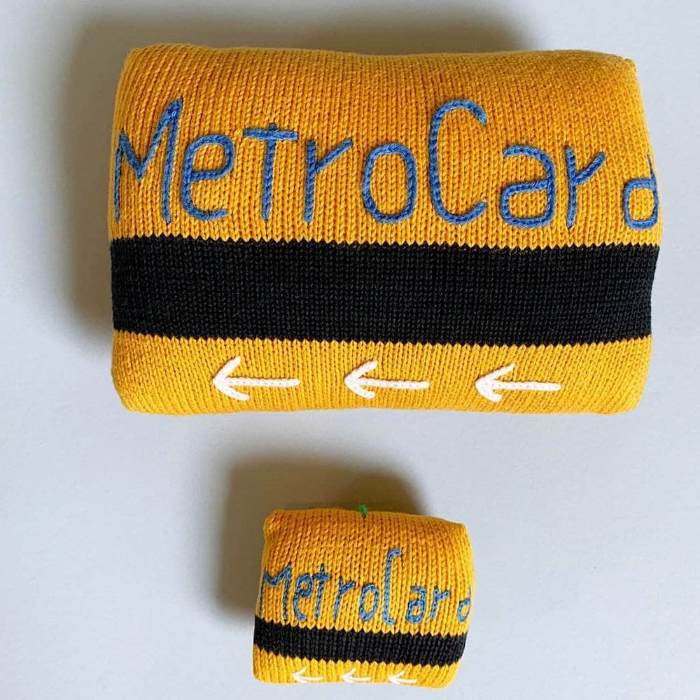 organic stuff toy metro card. Yellow, black and blue stitches letter and white stitches arrow.