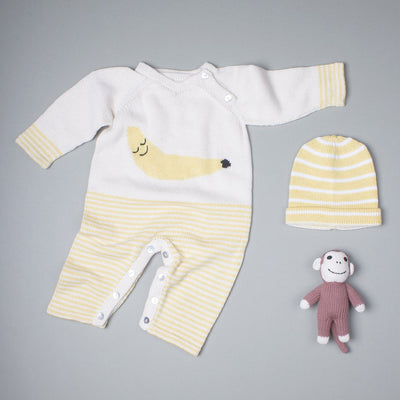 organic baby gift set. long sleeve banana graphic romper, yellow stripes hat, and monkey rattle.