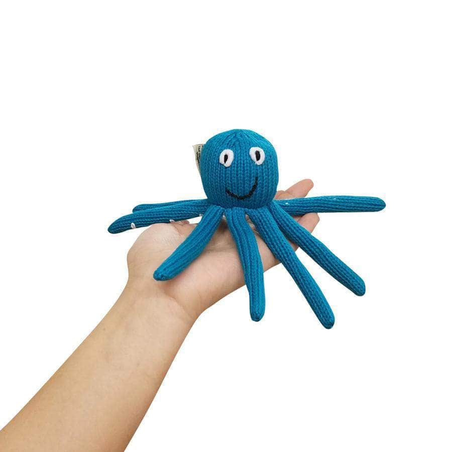 organic turquoise octopus with white eyes on model hand.