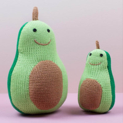 Avocado doll shown with smaller rattle toy. Both knit baby gifts have 2 shades of green, a smile and a brown pit.